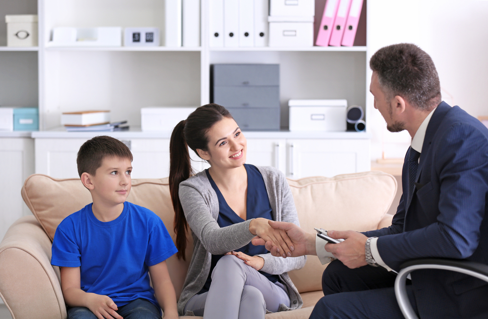 A mom and her son meet with his teacher during parent-teacher conferences