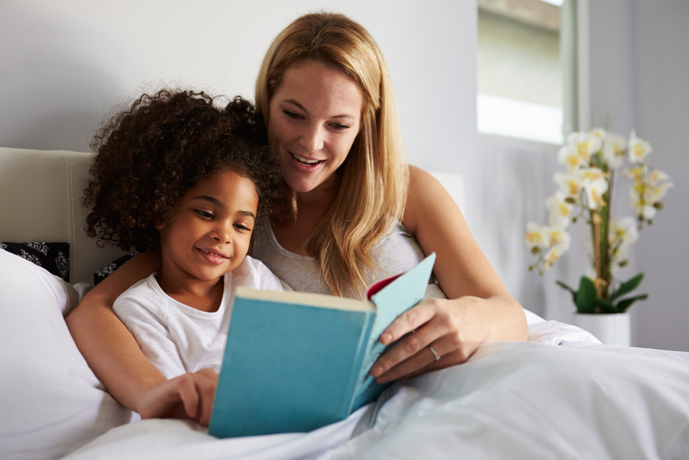 A mom reads with her daughter before bedtime