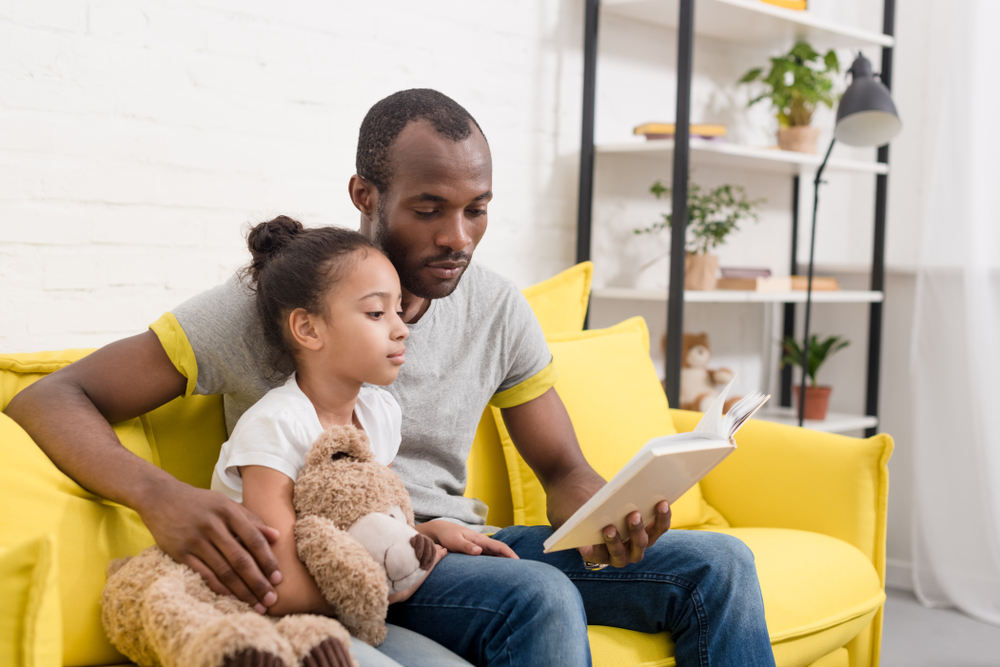 Parent modeling fluent reading to their young child