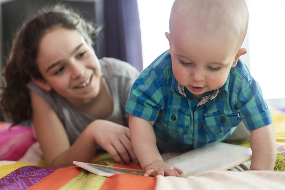 Sister helping her brother to learn how to read