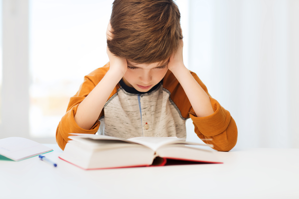 Child struggling with reading comprehension illustrating common causes of poor understanding.