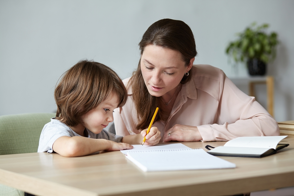 Little kid excitedly writing and sketching in notebook