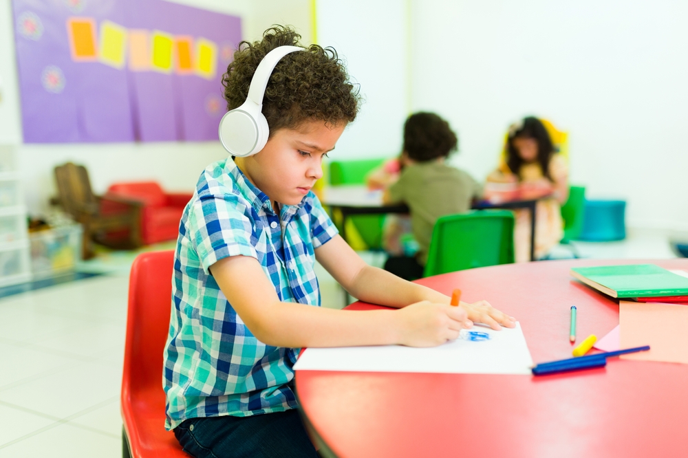 Young child with autism engaging in art therapy with sensory headphones