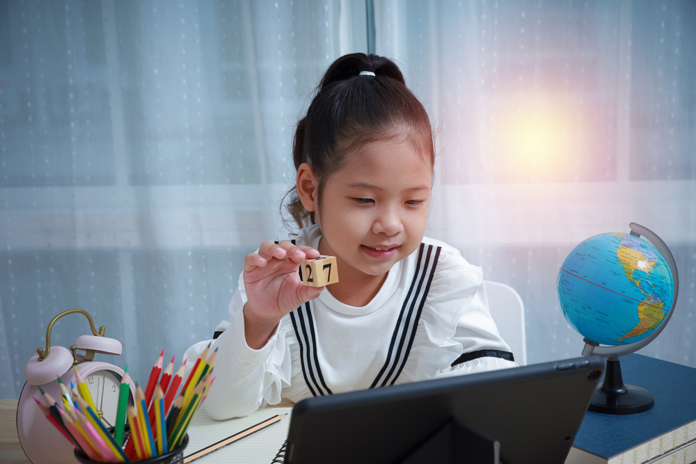 Young girl using a learn to read app on a tablet for educational development