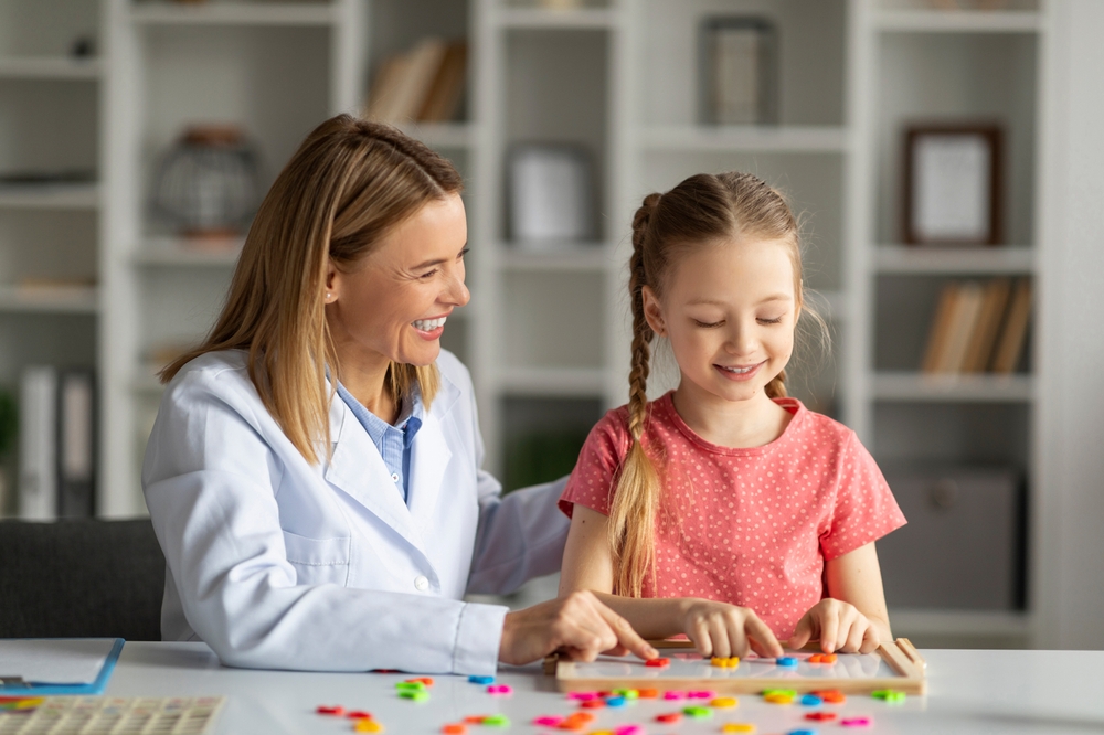 Child learning cognitive development stages through interactive play with an educator