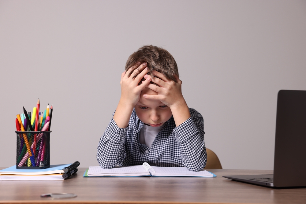 Child frustrated with reading, early warning signs of dyslexia