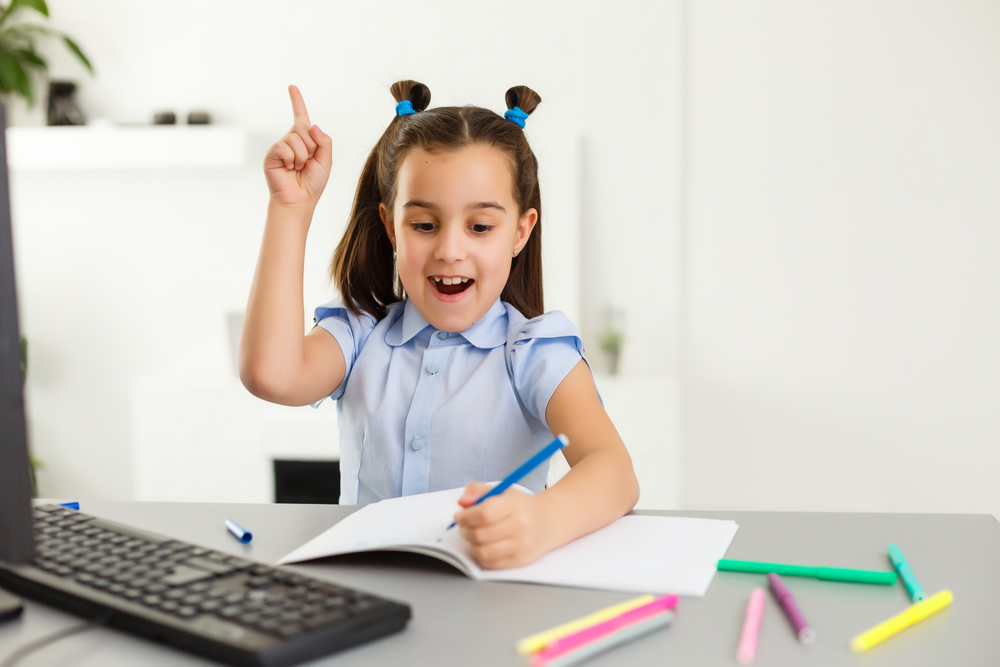 Girl participating in reading tutoring near me with colorful pens on desk