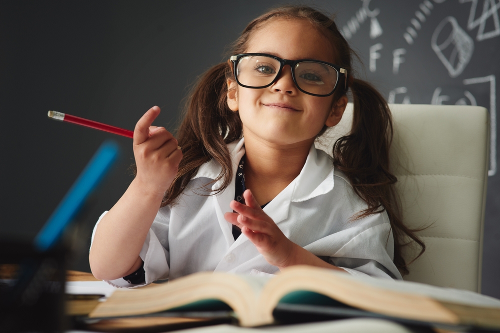 Young girl in glasses and lab coat with books, illustrating science of reading strategies