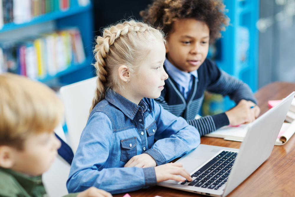 Children using a laptop for a reading program for kids