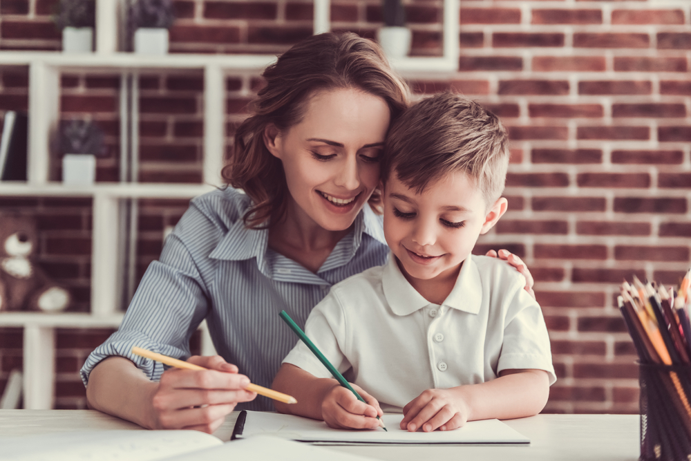 Parent guiding young child in writing practice