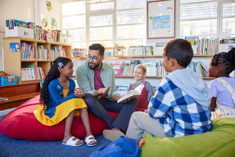 Teacher and children in library discussing how to teach reading